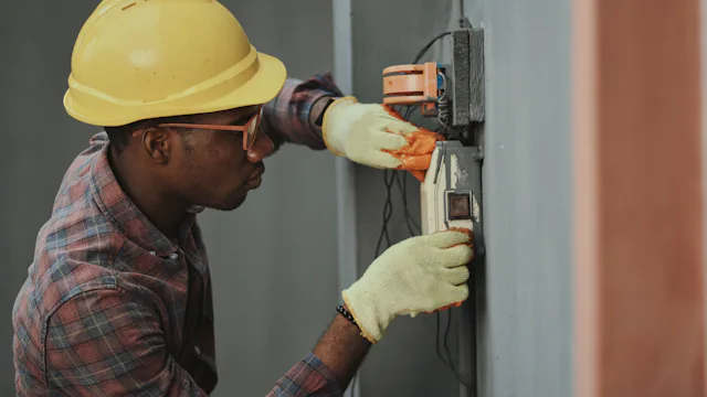 Electrician in a hard hat installing wiring